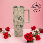 Tan 40oz handled tumbler with laser engraved Valentine heart doodle full wrap, styled with red roses
