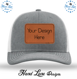 Heather gray and white Richardson 112 trucker hat with custom leatherette patch mockup on the crown