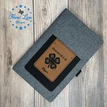 Gray canvas journal with engraved leatherette phone pocket showing 4-H clover logo