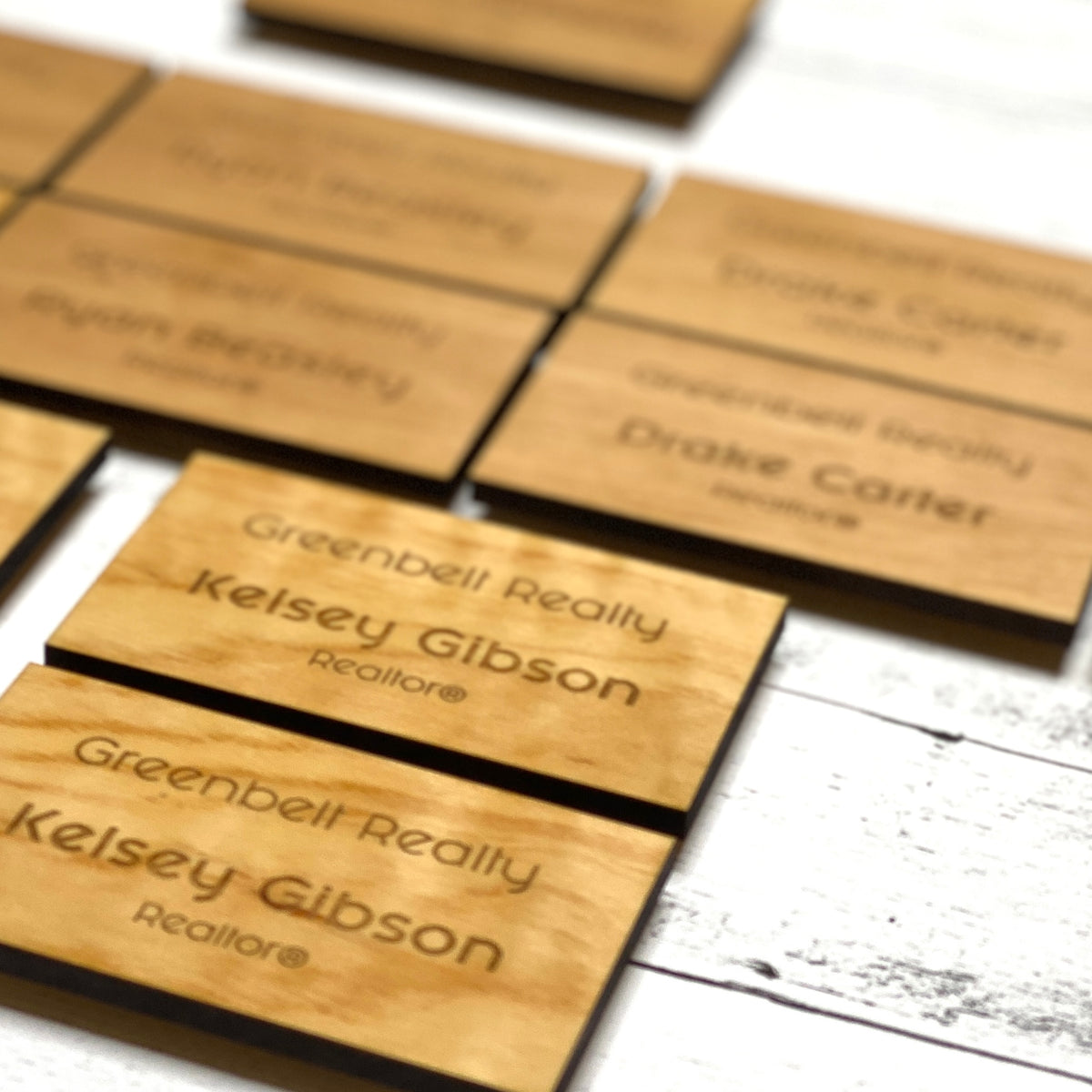 Assorted custom wood name badges laser engraved with realtor names for Greenbelt Realty