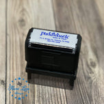 Black self inking teacher stamp with custom blue business imprint shown on rustic wood