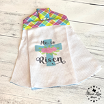Hanging Easter kitchen towel with He Is Risen blue cross and pink flowers, plaid snap-button top