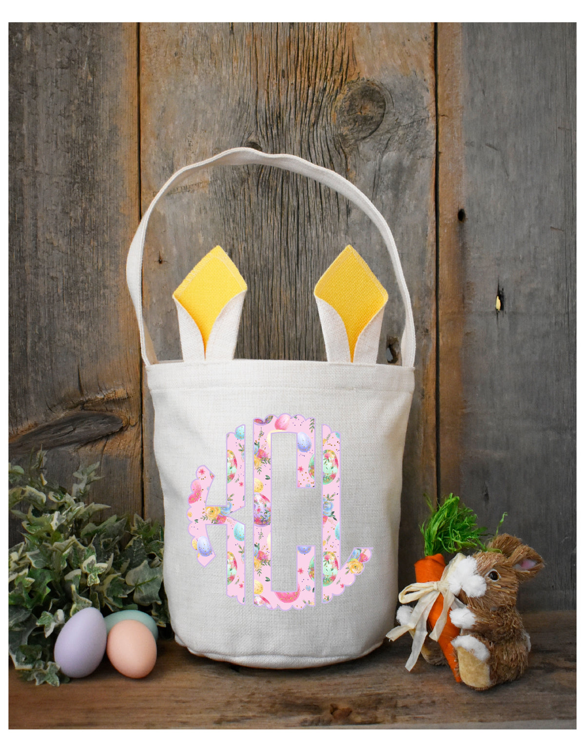 Personalized kids Easter basket with yellow bunny ears and pink floral monogram, styled with eggs