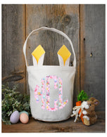 Personalized kids Easter basket with yellow bunny ears and pink floral monogram, styled with eggs