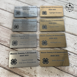 Silver and gold ID badges engraved for Nueces County 4-H Council and Ambassadors