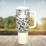 Cream 40oz Stanley Quencher tumbler laser engraved with cow print pattern and Stanley logo